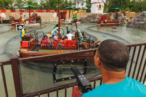 Guest aiming a water cannon at a pirate-themed boat ride at LEGOLAND Florida.